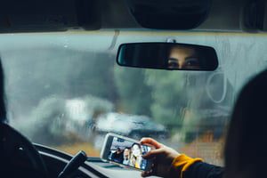 Driver distracted with a phone while driving in the rain