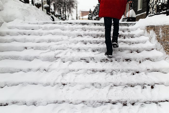 Person walks carefully up a staircase to avoid injuries